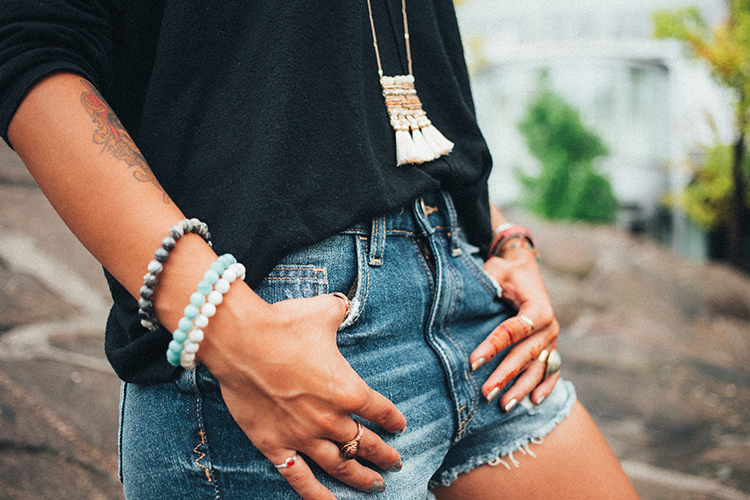 Woman wearing denim shorts with her thumbs in pockets