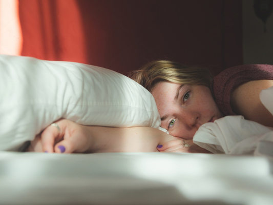 Woman lying in bed with a blurred background